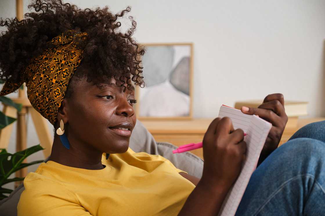 A woman writing in a notebook. A woman writing in a notebook.