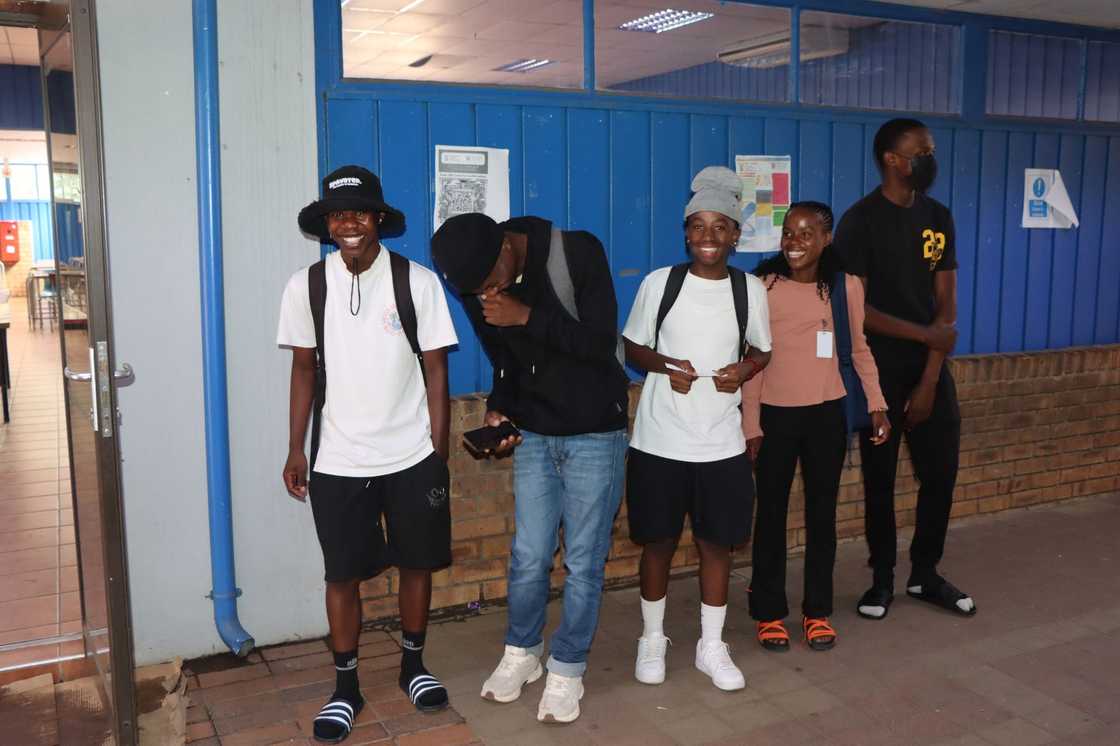 Tshwane South TVET College students in backpacks laughing on campus Tshwane South TVET College students in backpacks laughing on campus