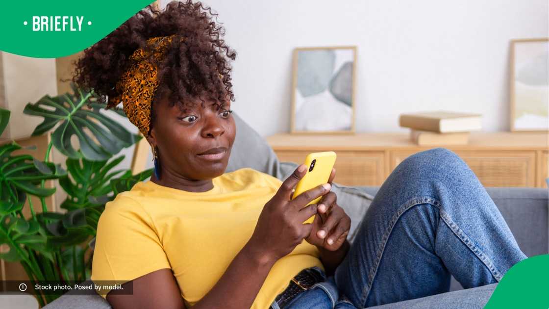 A surprised woman looking at her phone.