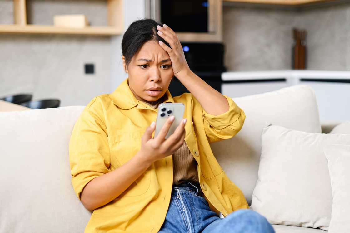 A scared woman looking at her phone.