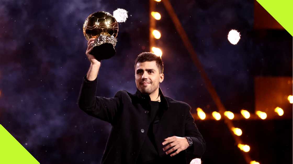 Rodri hoists his Ballon d'Or Award to Manchester City fans. Rodri hoists his Ballon d'Or Award to Manchester City fans.