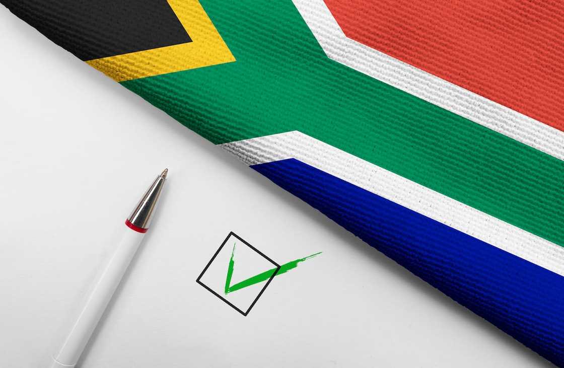 South African flag on white background with check box and pen South African flag on white background with check box and pen
