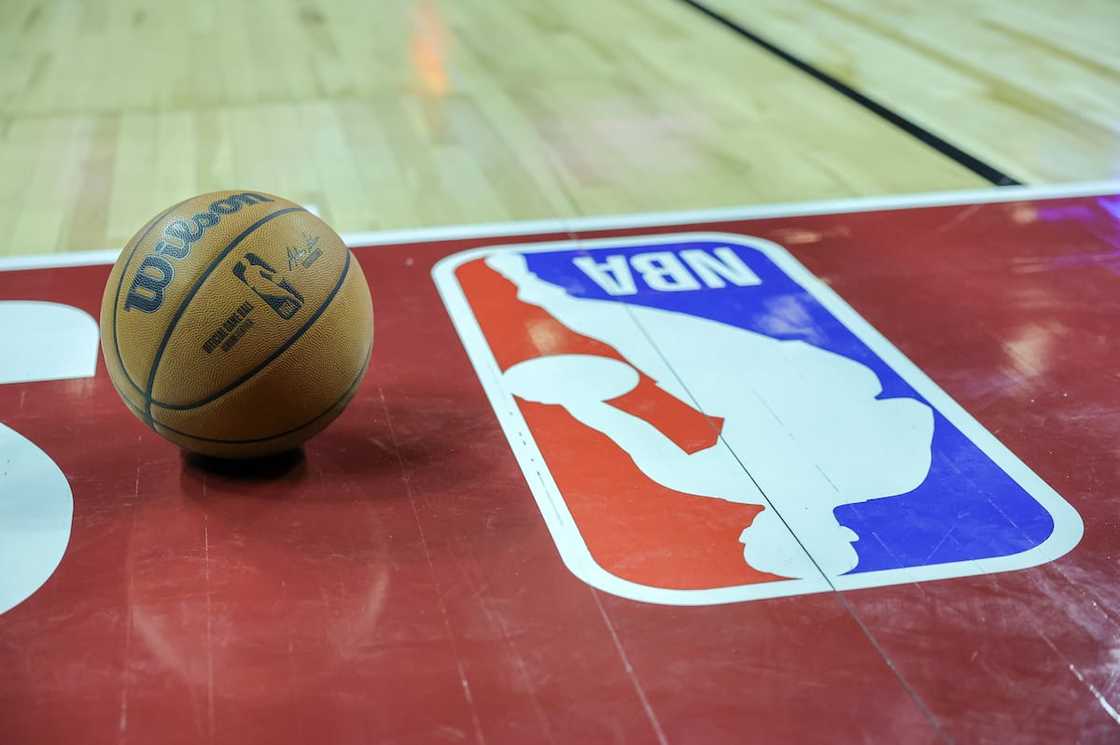 Basketball next to an NBA logo Basketball next to an NBA logo