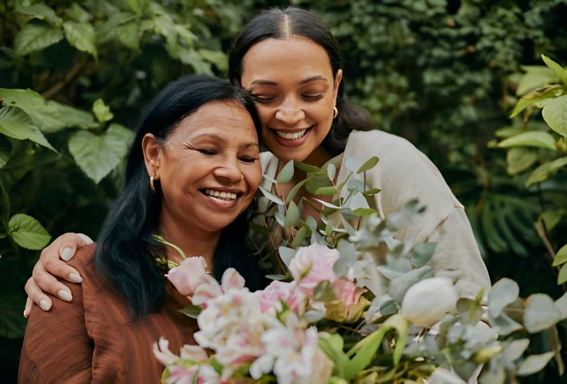 A daughter giving her mother a beautiful bouquet of flowers.