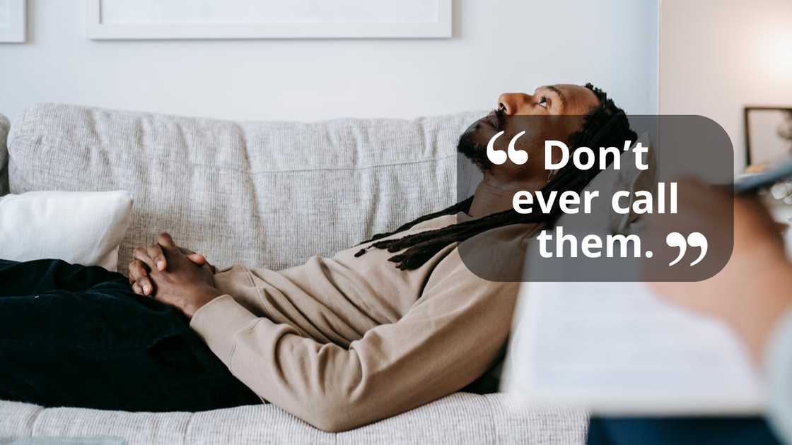 A man reclines on a couch talking to a person.