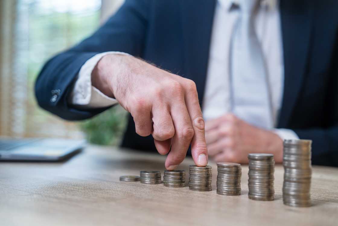 A businessman counting coins. A businessman counting coins.