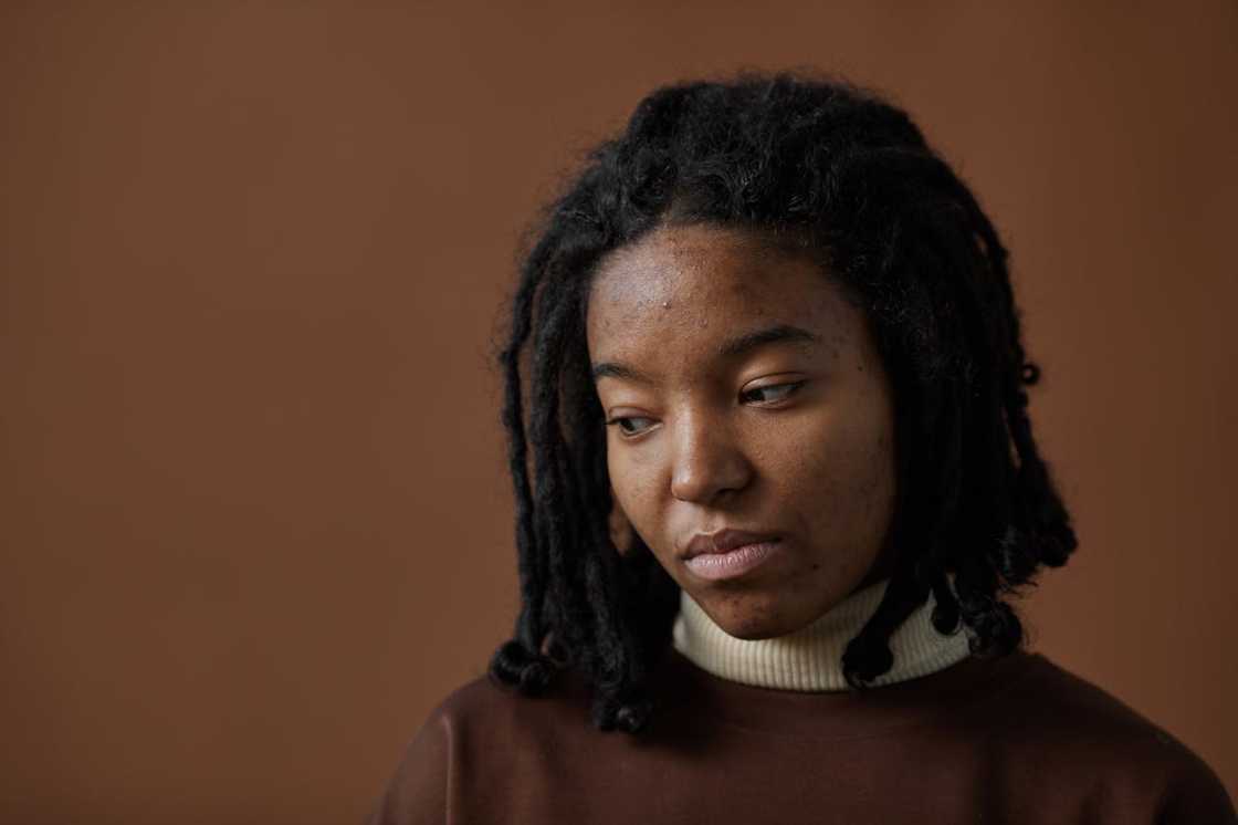 A woman with an expressionless face looks down. A woman with an expressionless face looks down.