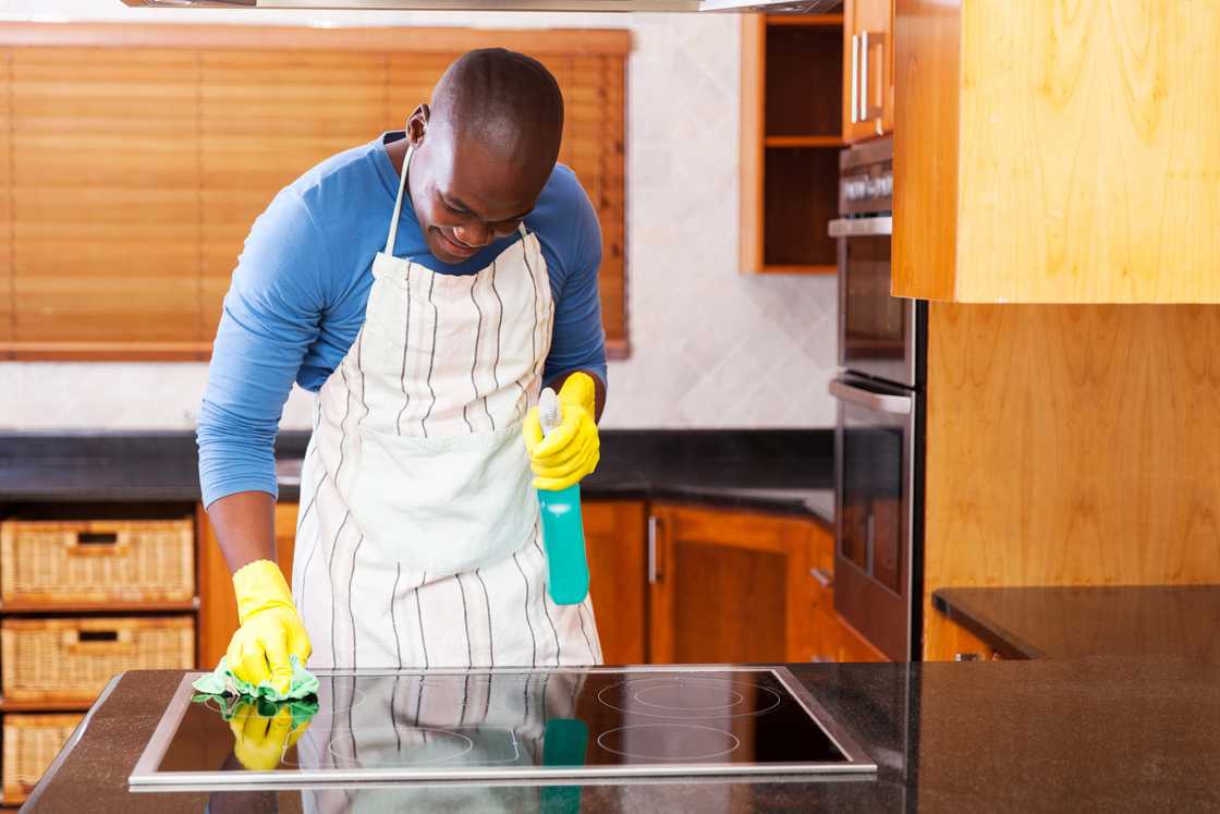 A man wiping kichen counters