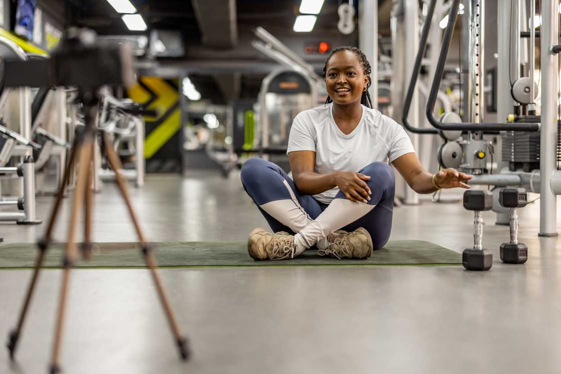 A lady recording a routine in the gym