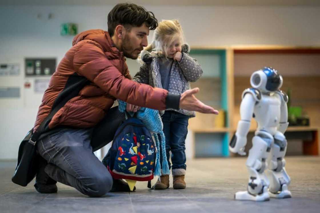 A father introduces his daughter to a robot called Nao in a Swiss creche A father introduces his daughter to a robot called Nao in a Swiss creche