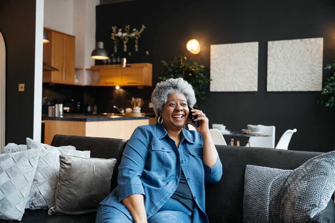 An elderly woman talks on the phone
