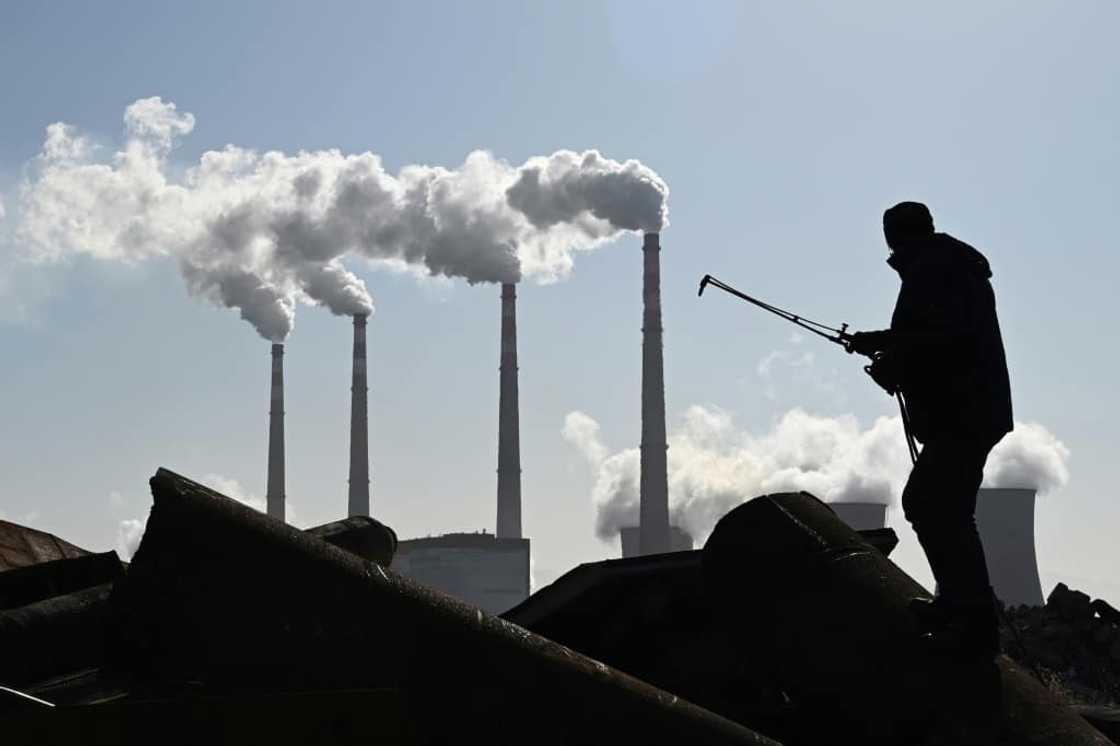 A worker using a torch to cut steel pipes near the coal-powered Datang International Zhangjiakou Power Station in China's northern Hebei province in November 2021 A worker using a torch to cut steel pipes near the coal-powered Datang International Zhangjiakou Power Station in China's northern Hebei province in November 2021