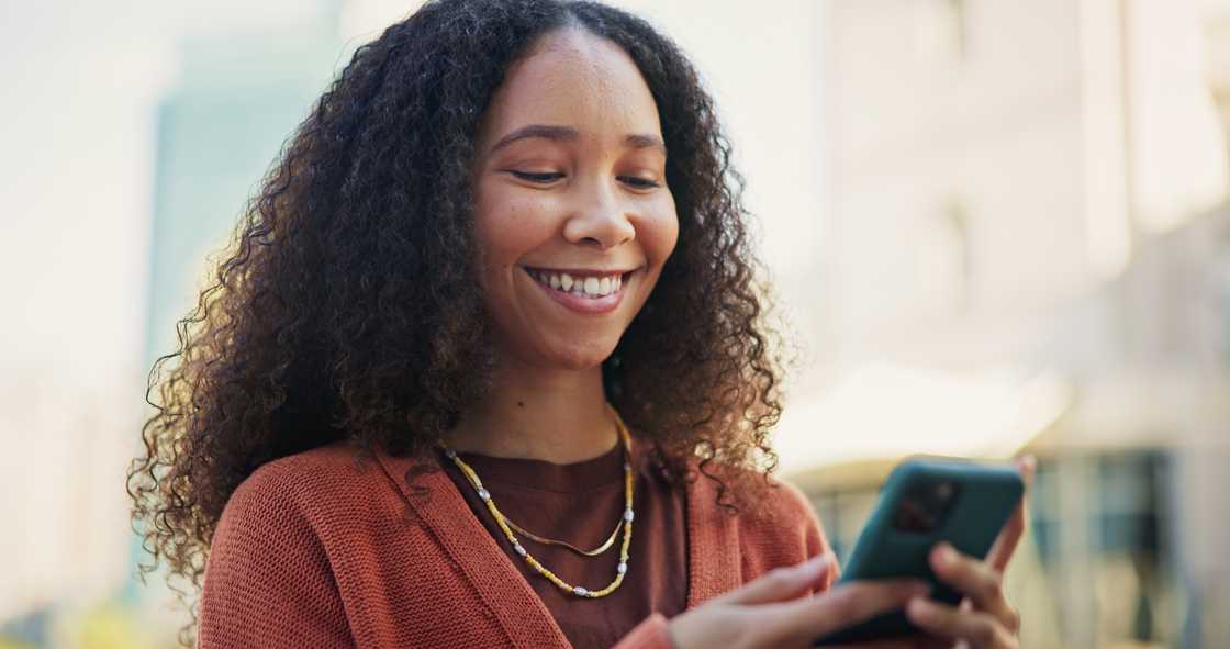 A woman smiling at her phone. A woman smiling at her phone.