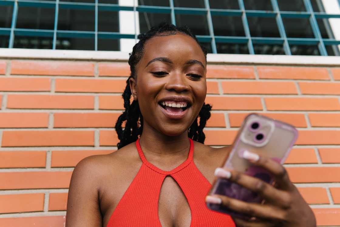 A woman smiling at her phone.