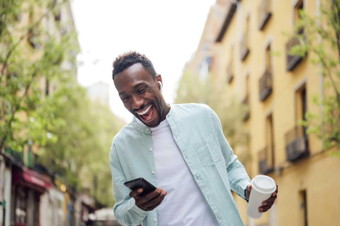 A man laughing at his phone.