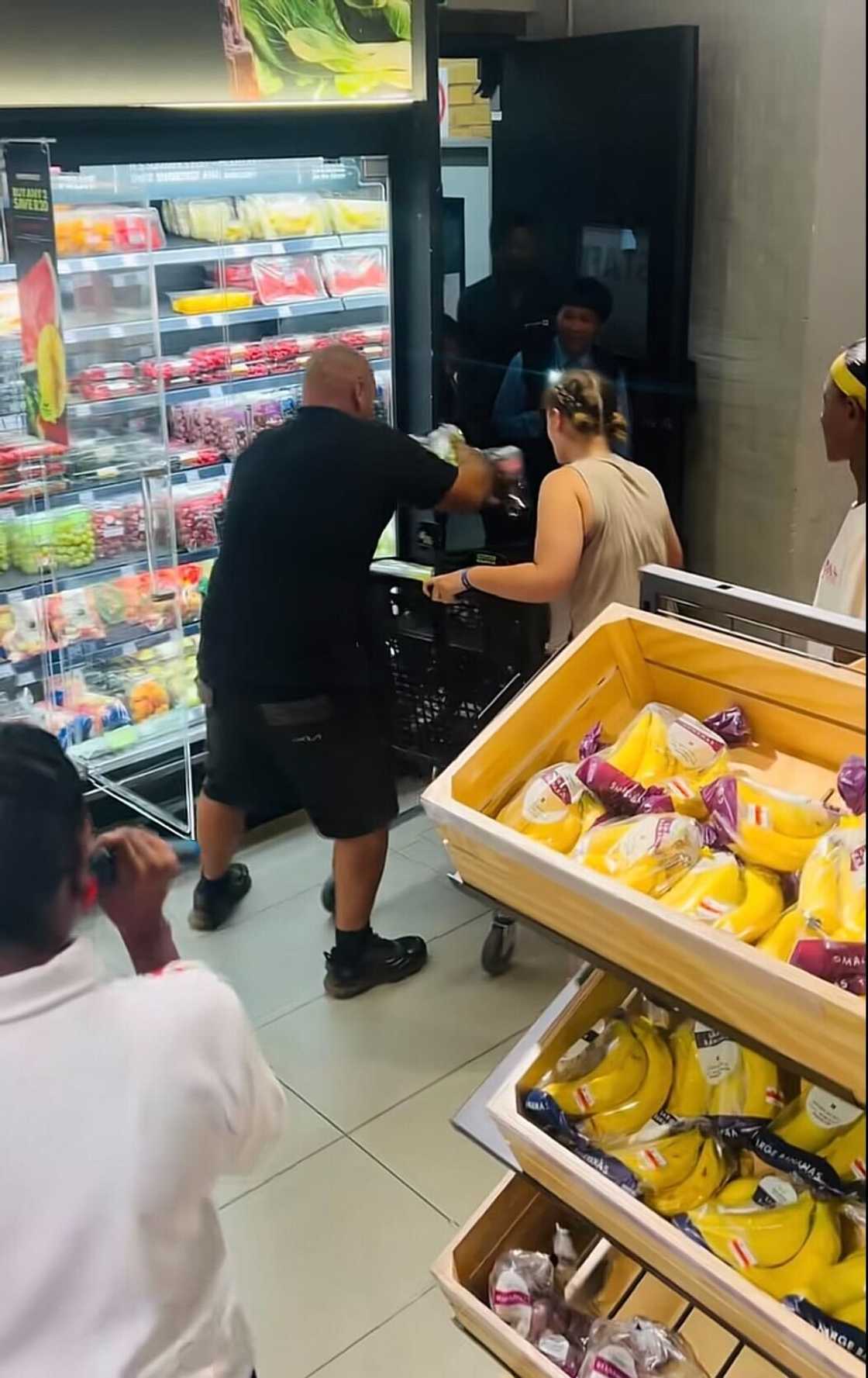 A father grabbed items from the fridge in a Woolworths shop during a trolley dash while his daughter pushed the trolley. A father grabbed items from the fridge in a Woolworths shop during a trolley dash while his daughter pushed the trolley.