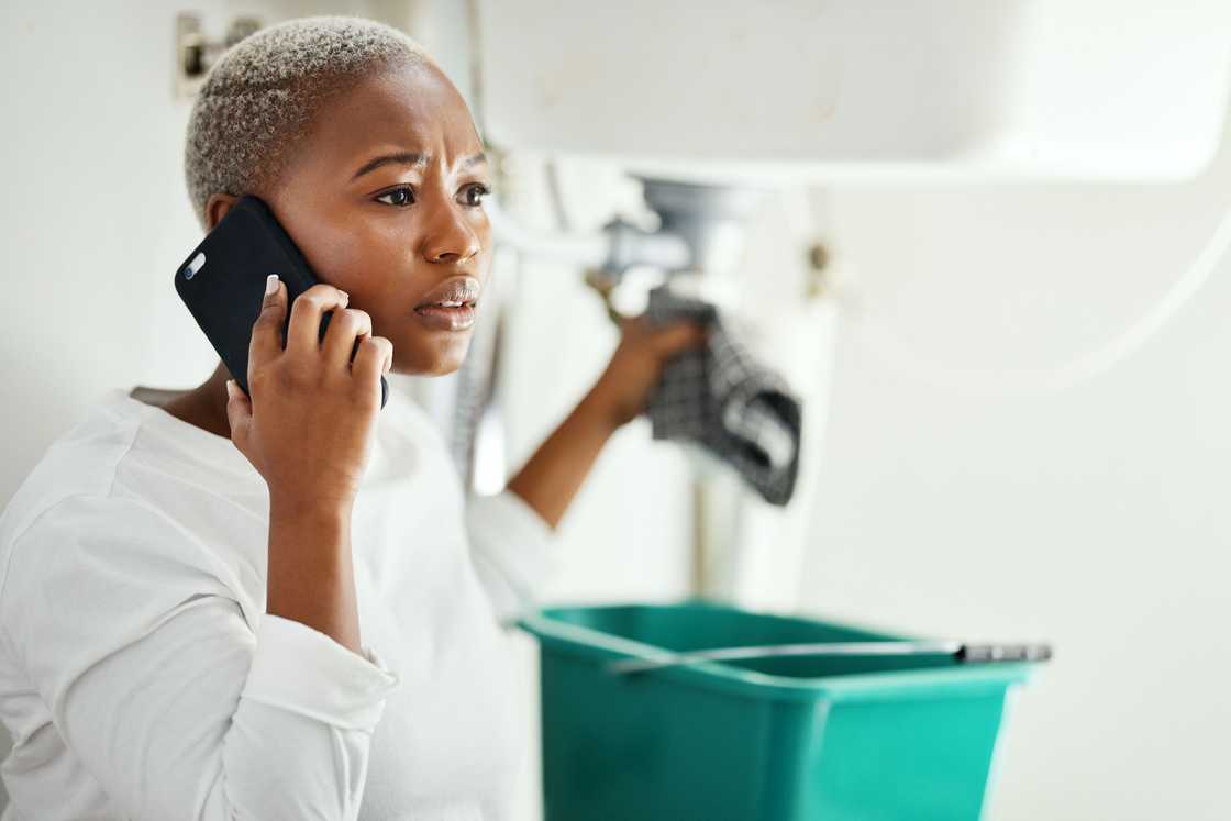 A lady receives a call while cleaning A lady receives a call while cleaning