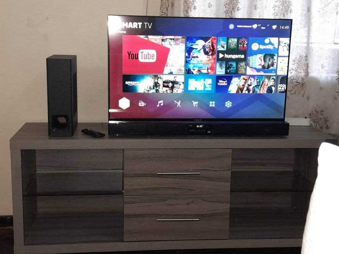 Woman shares a look at her TV and speaker on the table. Woman shares a look at her TV and speaker on the table.