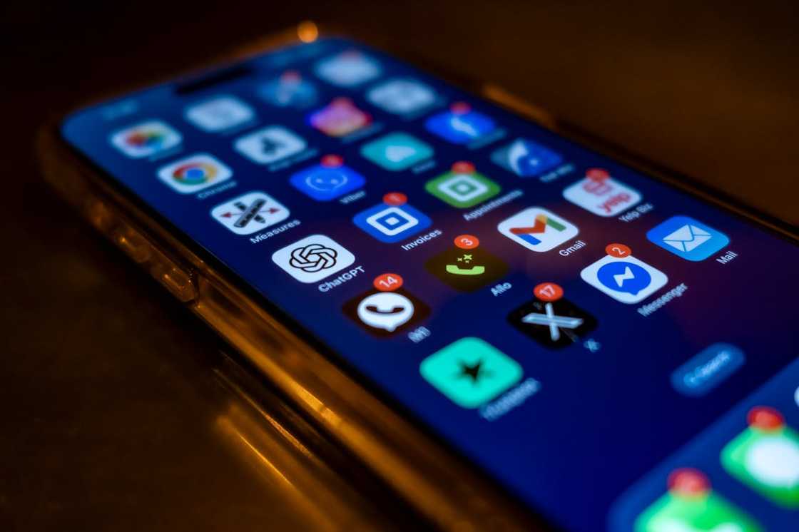 A smartphone screen showing multiple app icons in low light. A smartphone screen showing multiple app icons in low light.