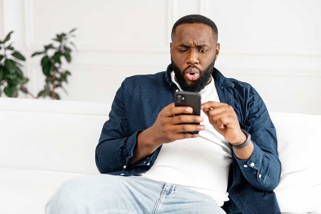A surprised man looking at his phone. A surprised man looking at his phone.