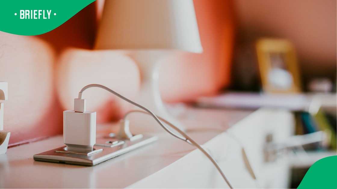 A cellphone charger plugged in. A cellphone charger plugged in.