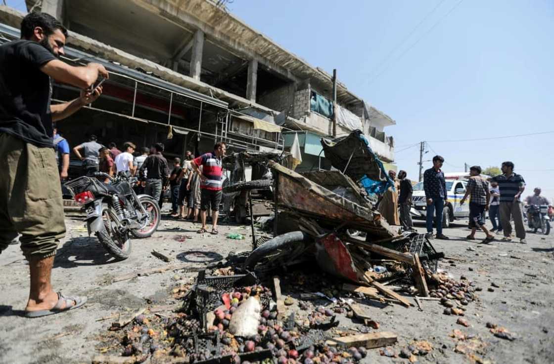 Syrian regime artillery fire on the town of Al-Bab, under the authority of Turkish-controlled Syrian forces, killed 15 civilians, a war monitor said -- people inspected damage at a market