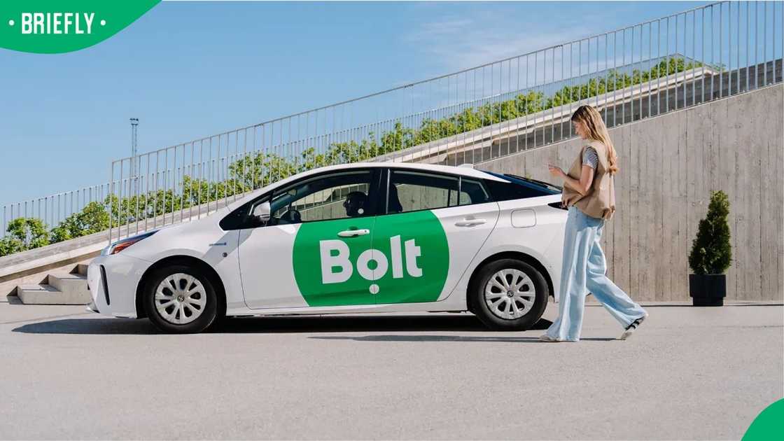 A woman walking to a Bolt vehicle.