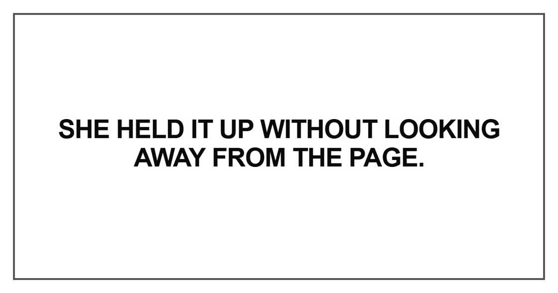 She held it up without looking away from the page.