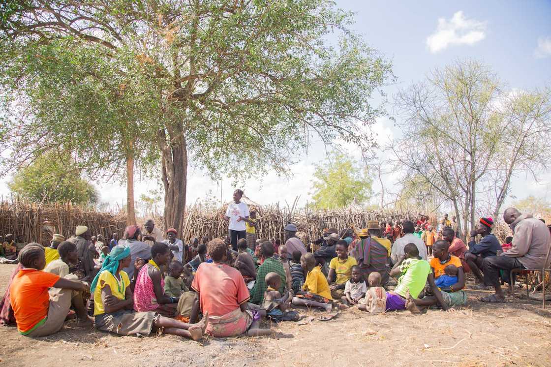 Rural community meeting held under a tree.