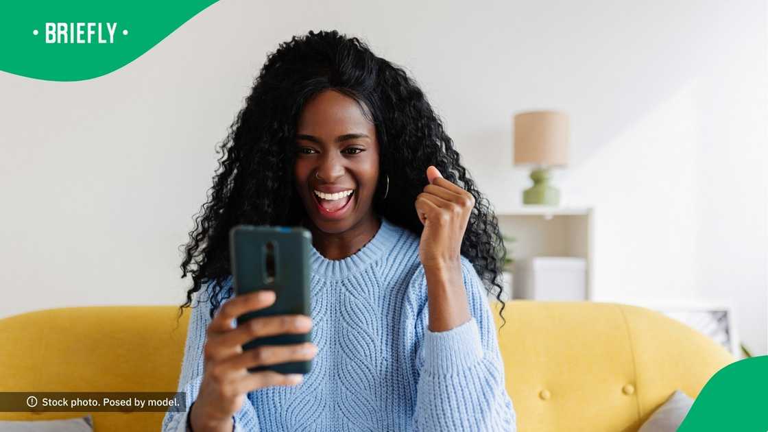 A woman smiling at her phone. A woman smiling at her phone.