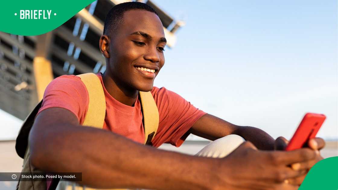 A man smiling at his phone. A man smiling at his phone.