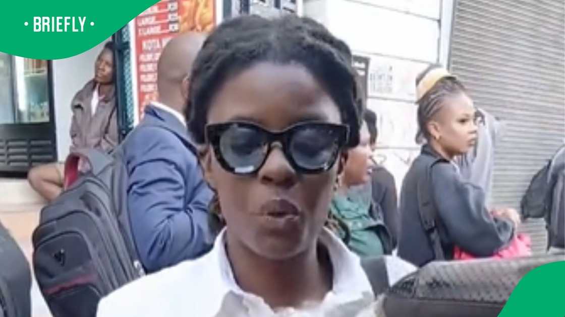 Woman sells water bottles at taxi rank