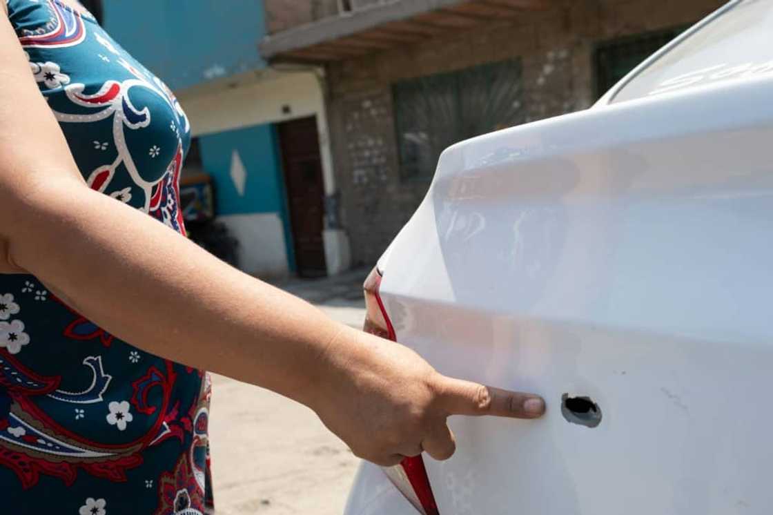A businesswoman shows a bullet hole in her vehicle fired by gang members intimidating her to pay for protection in Lima A businesswoman shows a bullet hole in her vehicle fired by gang members intimidating her to pay for protection in Lima