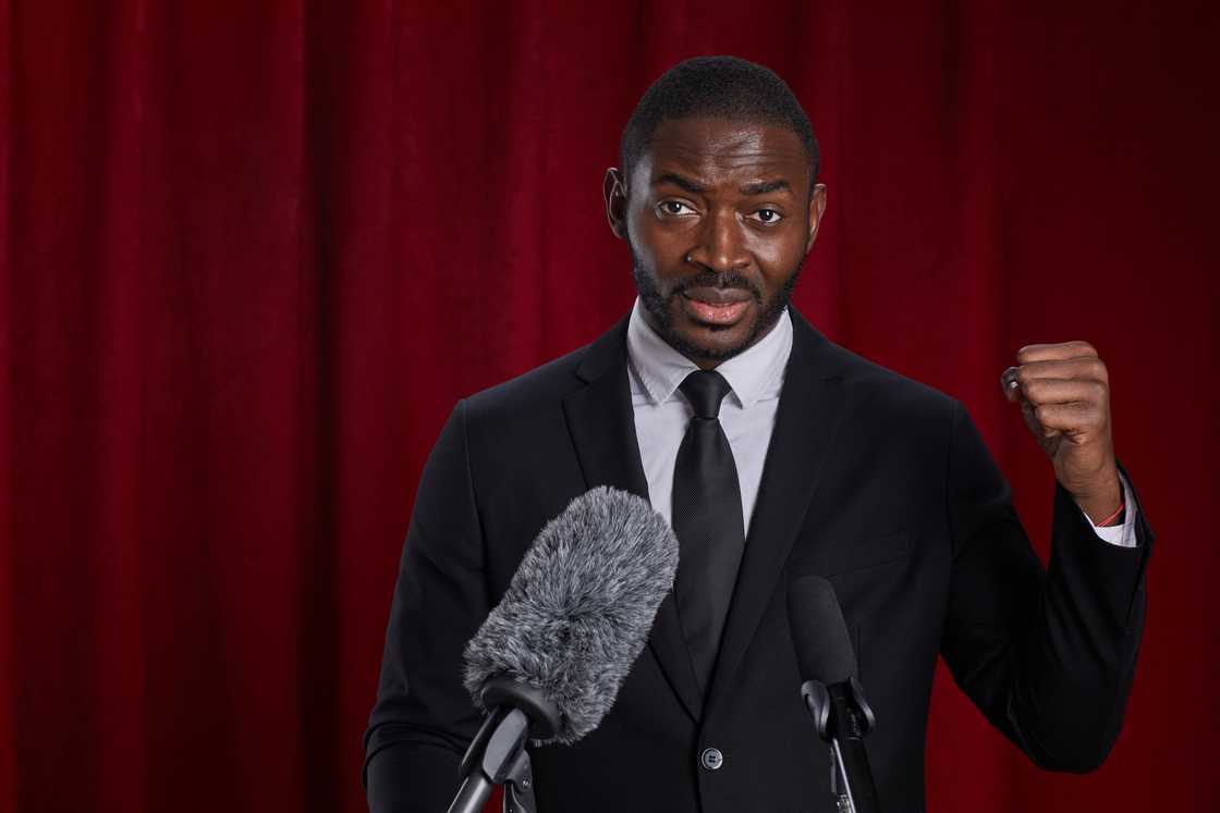 A young man at the pulpit speaking into a microphone. A young man at the pulpit speaking into a microphone.