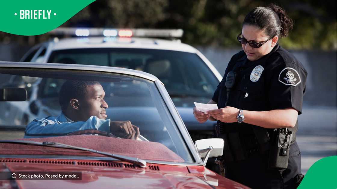 Officer checking a motorist's paperwork. Officer checking a motorist's paperwork.