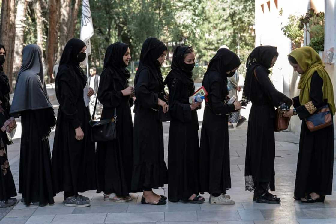 Dressed in black hijabs and headscarves, students queue for their entrance exams outside Kabul University Dressed in black hijabs and headscarves, students queue for their entrance exams outside Kabul University