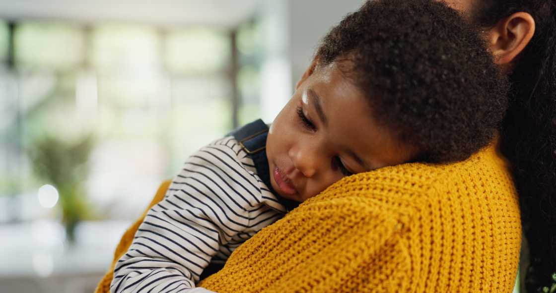 A mother holds her sleeping toddler