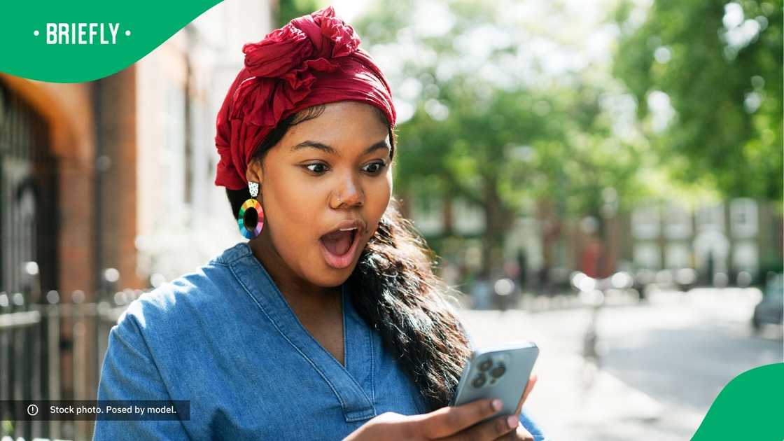A surprised woman looking at her phone.