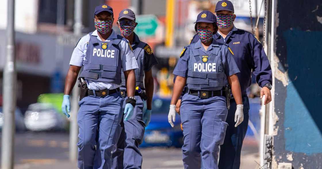 Members of the South African Police Service wear their face masks as they patrol the deserted streets of Woodstock on Day One of national lockdown in Cape Town