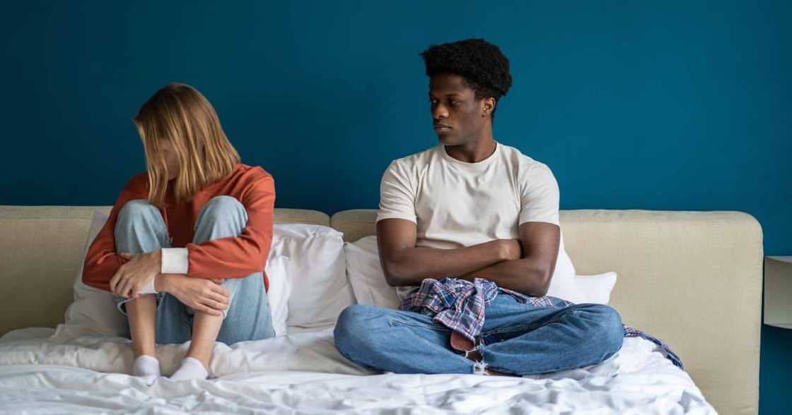 Woman ignores man on bed after fight Woman ignores man on bed after fight