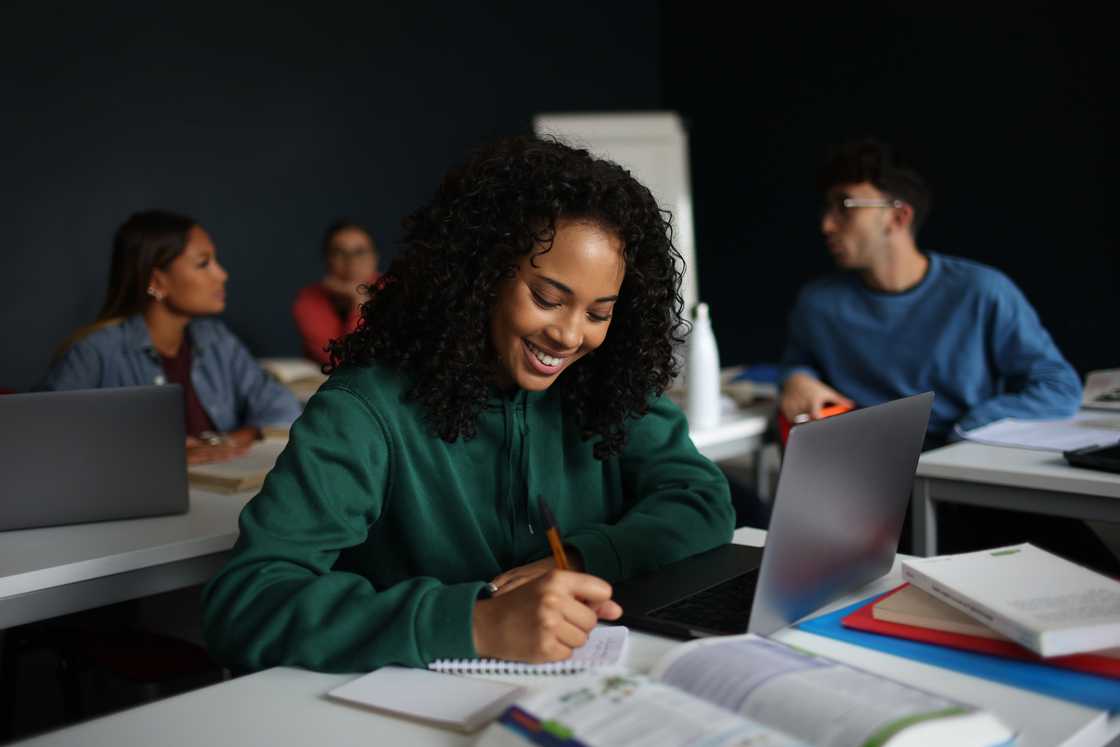 A student writing in her notebook. A student writing in her notebook.