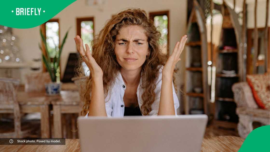 A confused woman looking at her laptop.