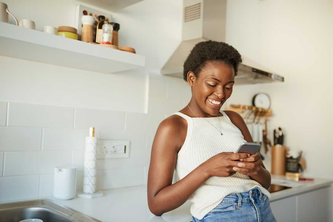 A woman smiling at her phone. A woman smiling at her phone.