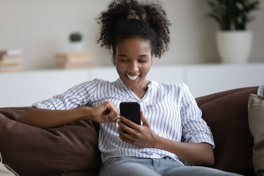 A woman laughing at her phone.