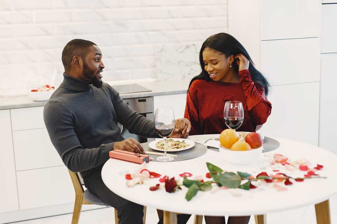 A couple enjoy a romantic dinner with wine at a table. A couple enjoy a romantic dinner with wine at a table.