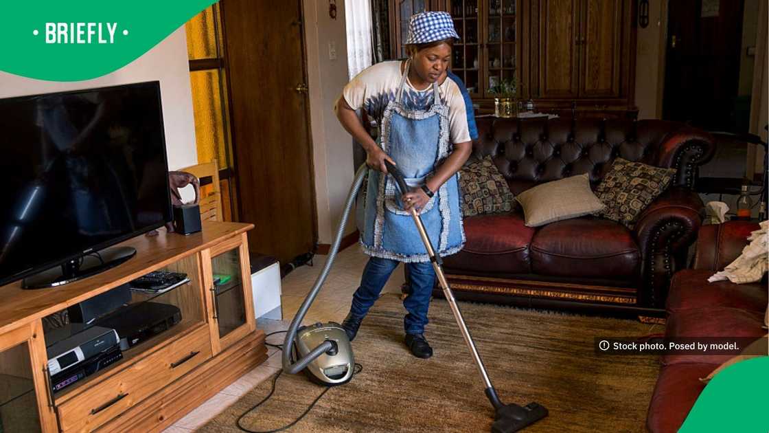 The image on captured a domestic worker vacuuming the floors
