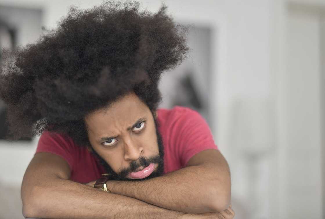A man rests his head on folded arms, looking frustrated. A man rests his head on folded arms, looking frustrated.