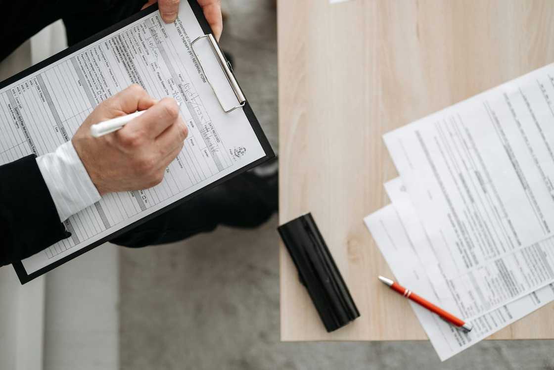 A person signing a form A person signing a form