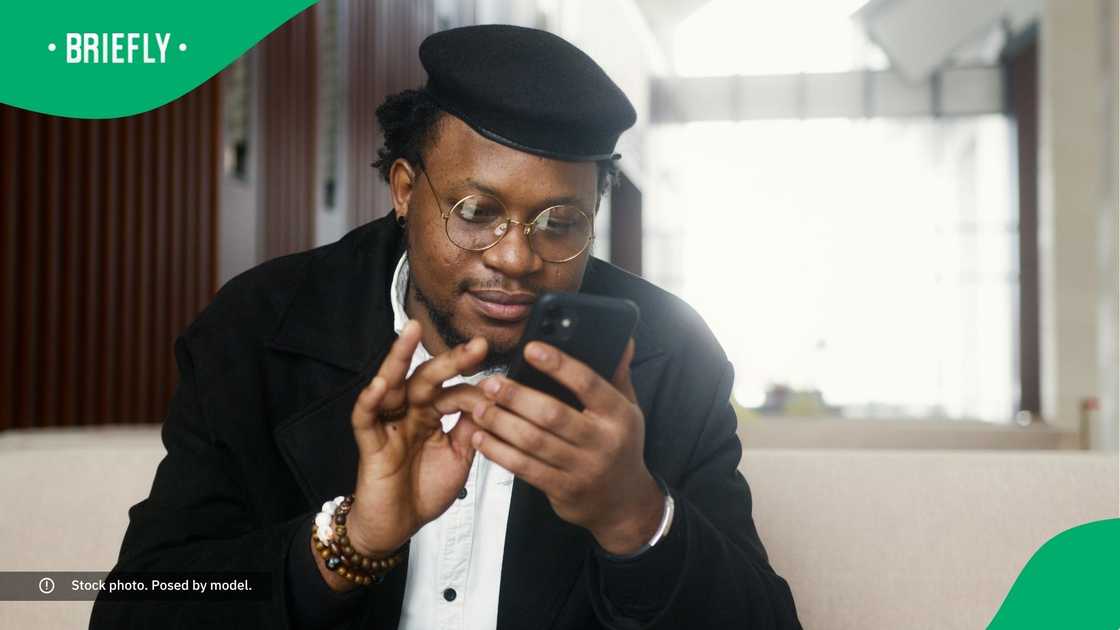 A man smiling at his phone. A man smiling at his phone.