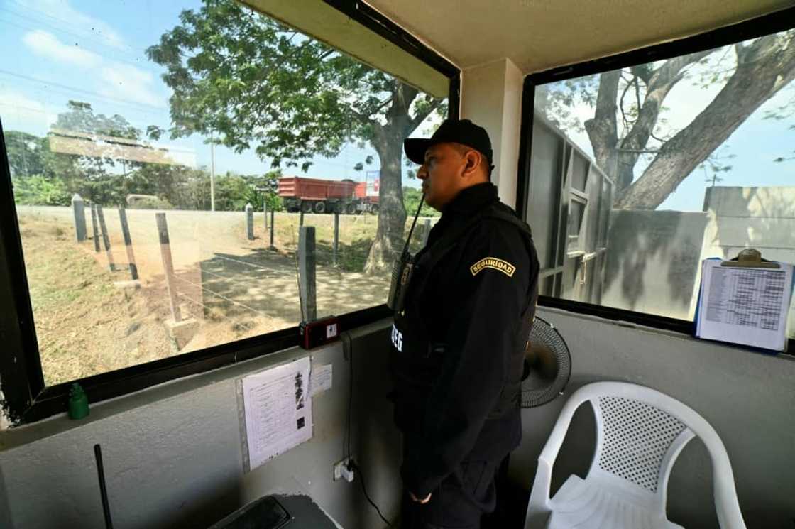 A security guard works at a shrimp farm in Taura, Ecuador. Business leaders complain that security forces are completely absent in some areas as crime gangs lurk